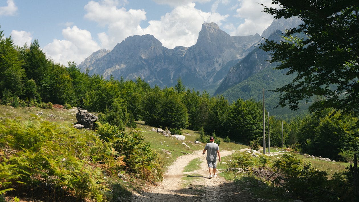 Hiker on a rugged mountain trail in the Albanian Alps near Theth with dramatic limestone peaks