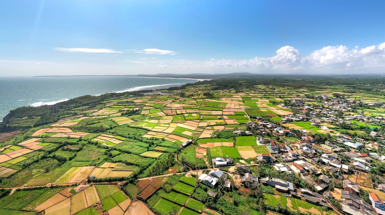 Aerial view of coastal farmland and sea on Awaji Island, Japan, with green fields meeting the shoreline