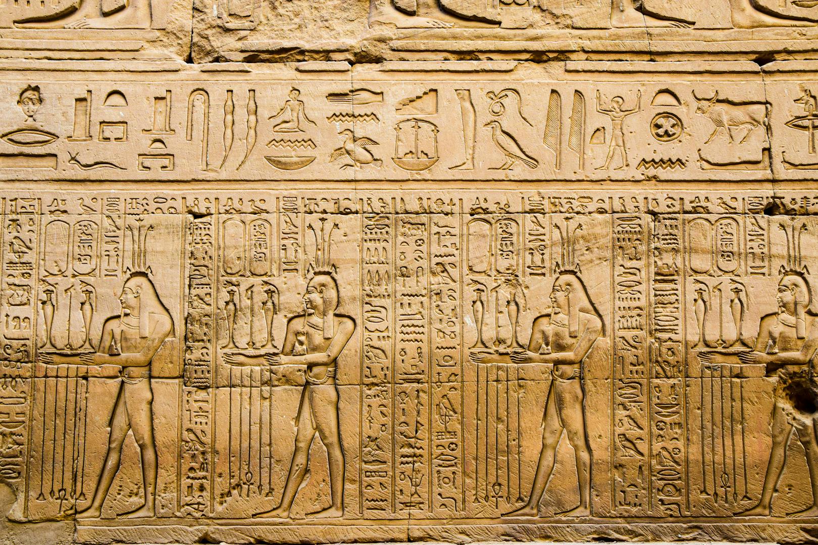 Ancient Egyptian hieroglyphs carved on temple walls