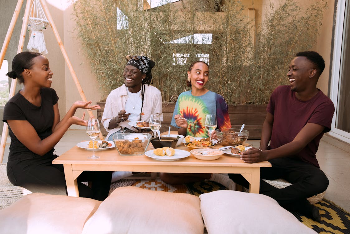 A cheerful group of friends bonding over an outdoor meal, enjoying conversation and laughter