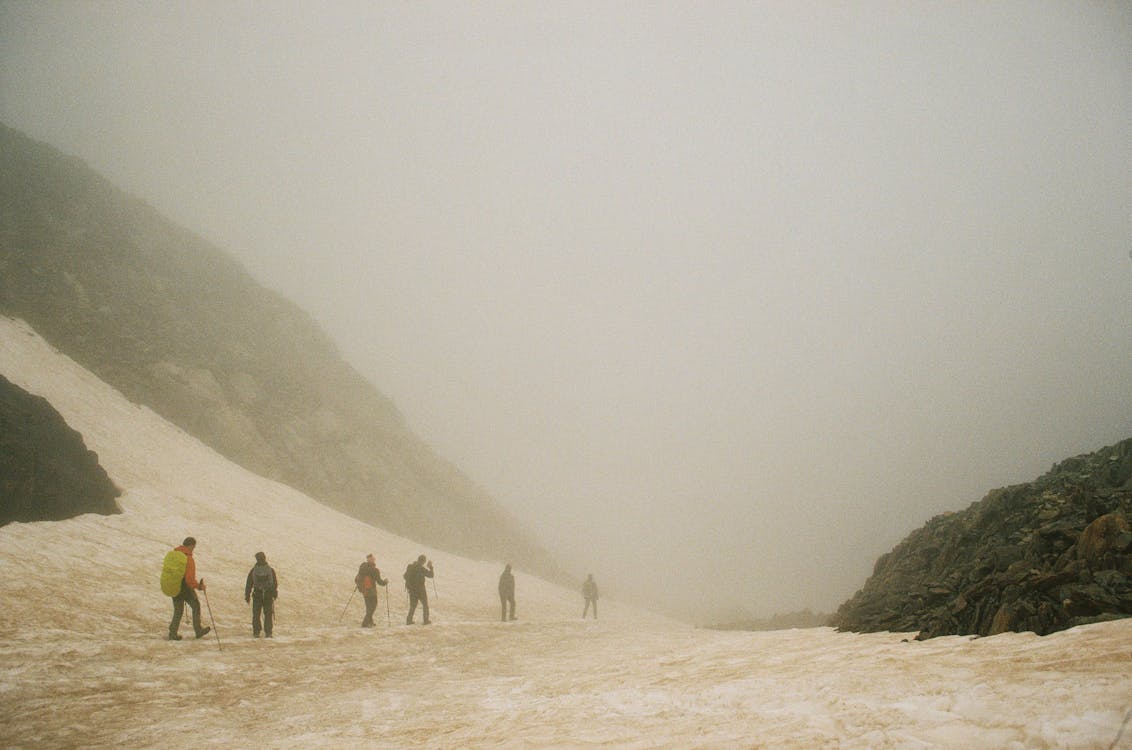 Group of hikers walking across a snow-covered mountain landscape in Iceland on a glacier adventure