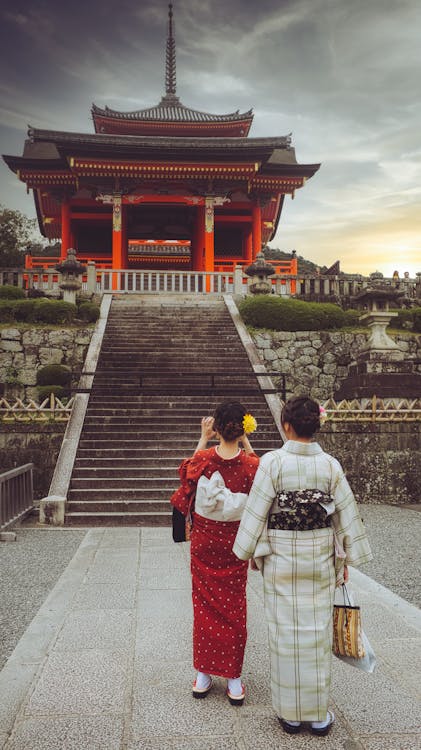 Two women in traditional kimonos exploring Kiyomizu-dera Temple, Kyoto, a popular experience on Japan group tours