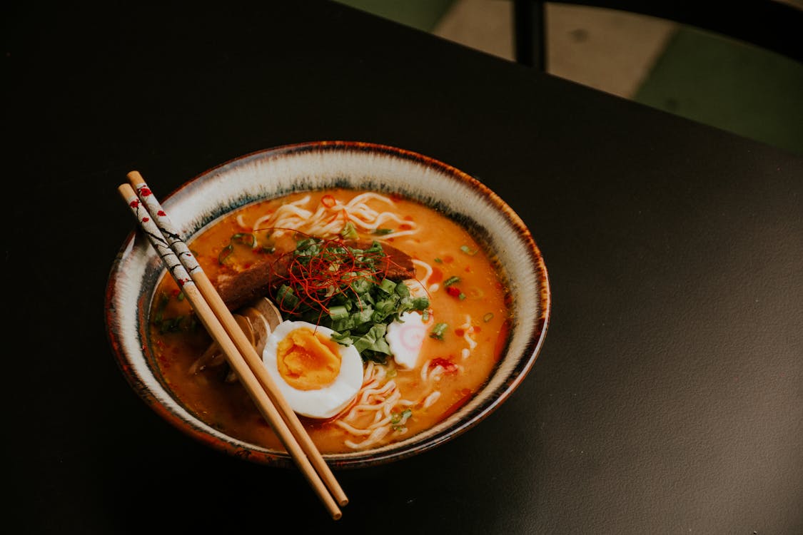 A steaming bowl of Japanese ramen with chashu pork, soft-boiled egg and noodles in a rich broth