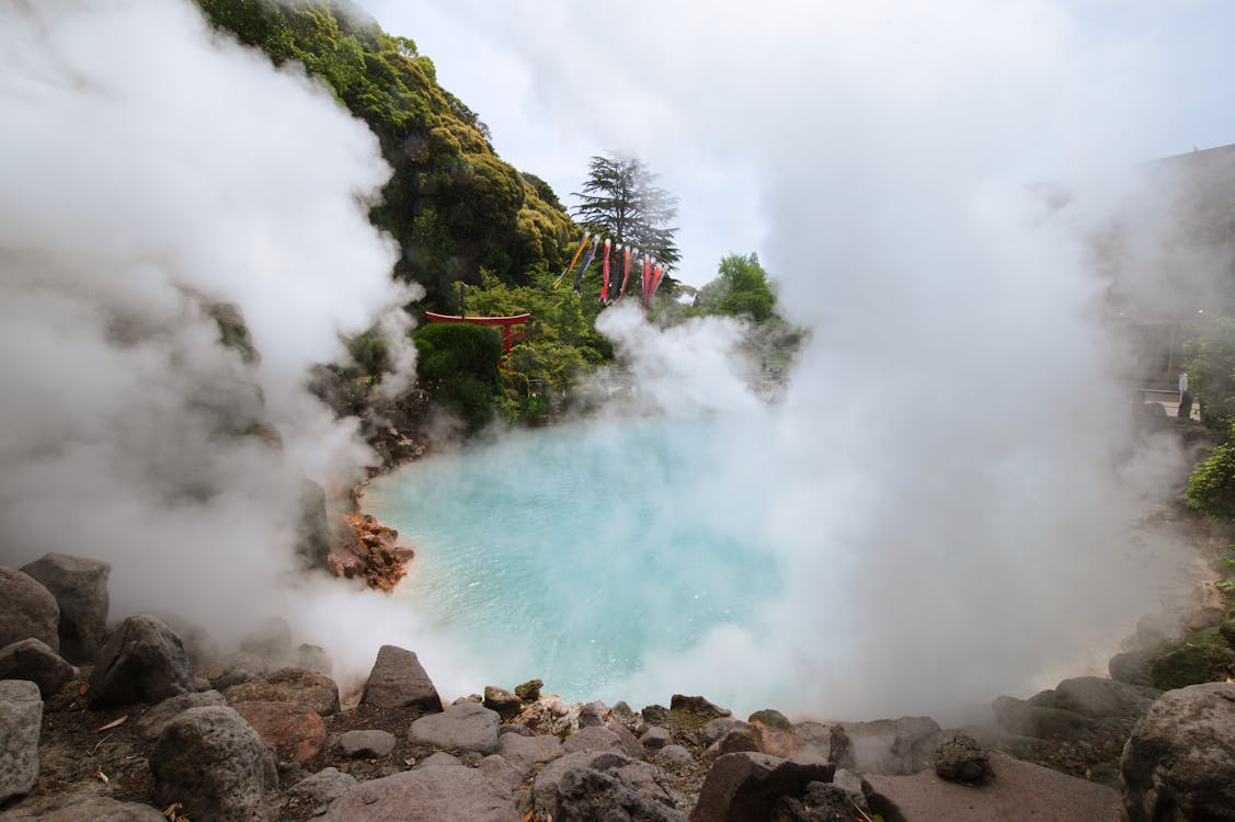 Steam rising from a geothermal hot spring in the forested Kiso Valley, Japan