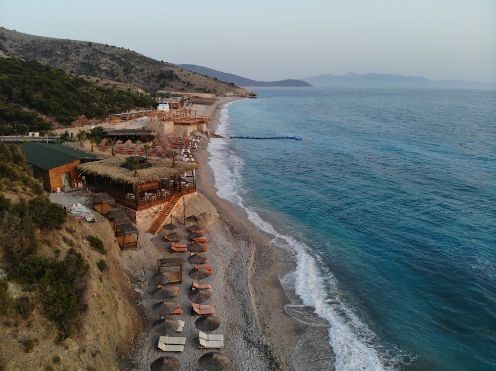 Aerial view of a turquoise beach resort on the Albanian Riviera with clear Ionian waters
