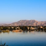 The Nile River in Egypt with lush green banks and distant desert mountains