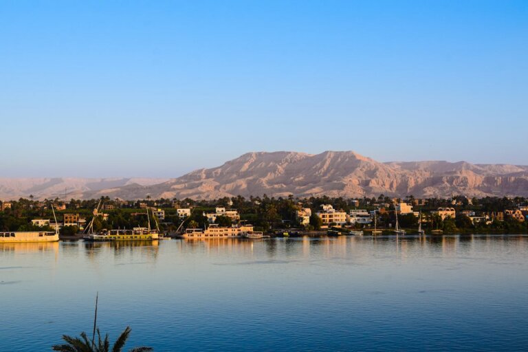The Nile River in Egypt with lush green banks and distant desert mountains