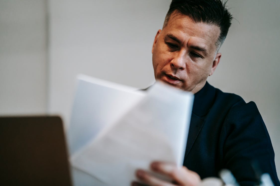 A professional carefully reviewing paperwork, the kind of thorough reading that catches warning signs before booking