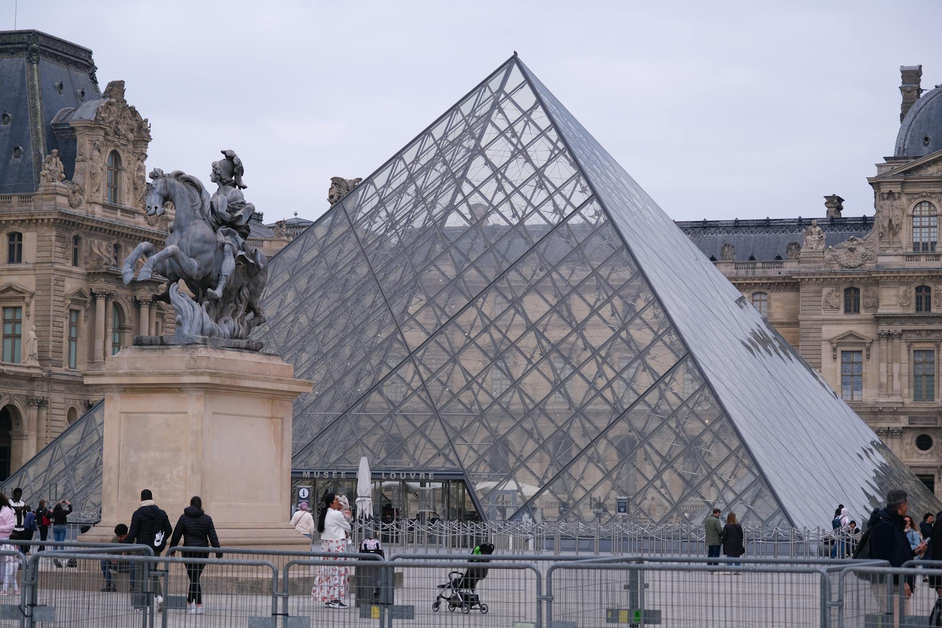 The Louvre glass pyramid entrance lit up at dusk in Paris