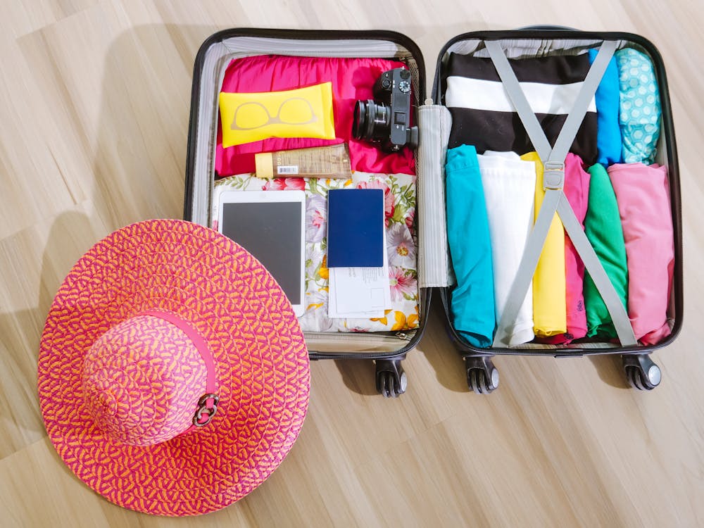 Woman packing a neatly organized suitcase on bed, preparing for international travel
