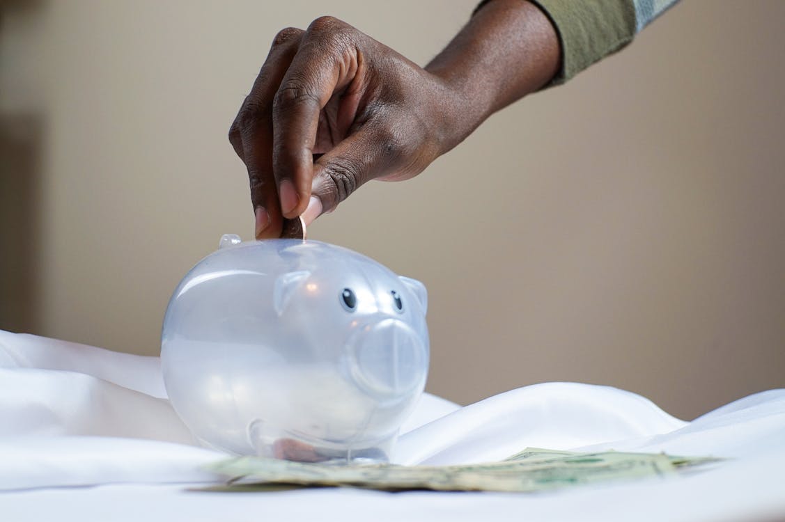 Savings jar with coins, the money side of smart tour booking timing