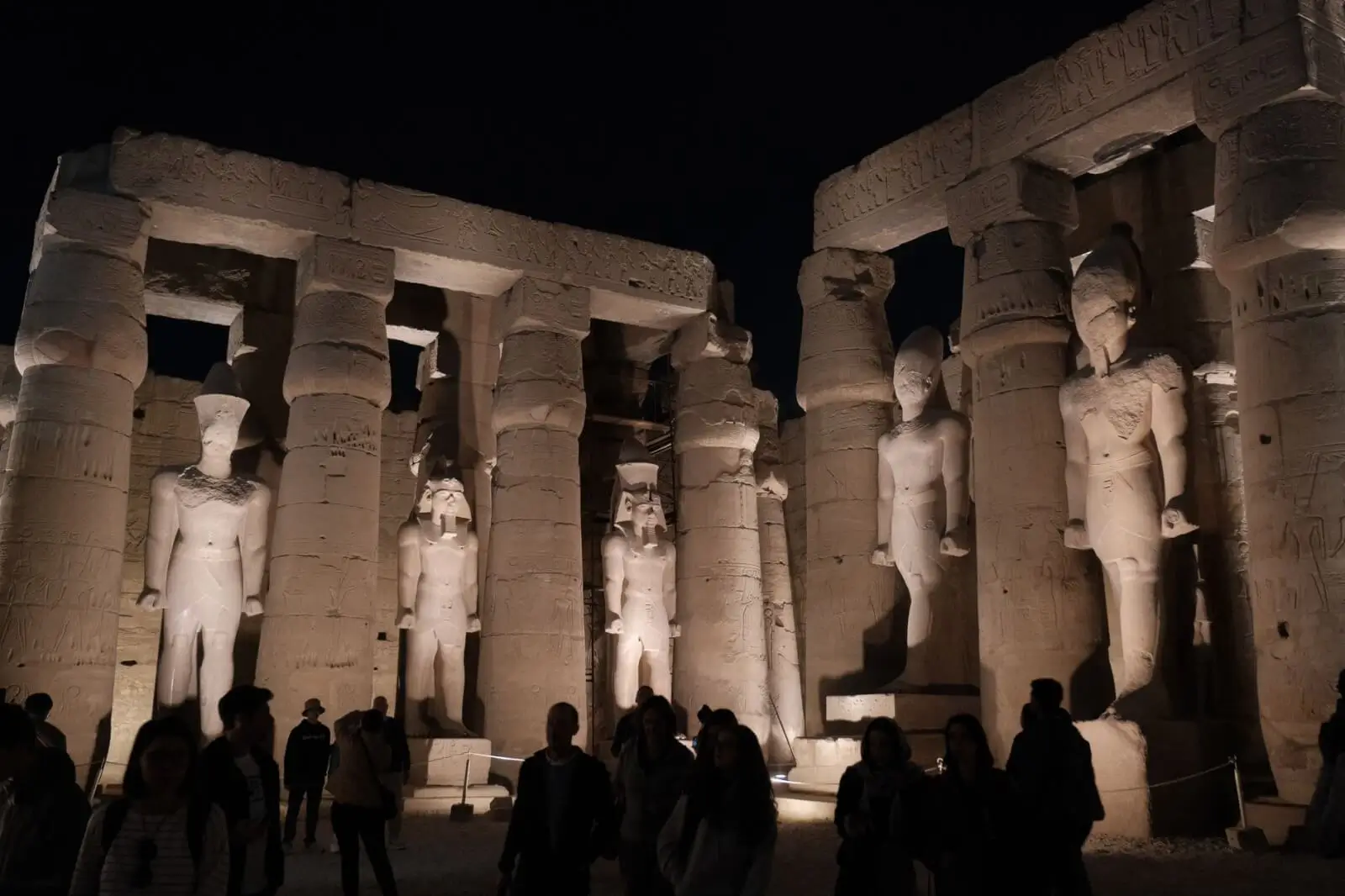 The grand hypostyle hall of Karnak Temple illuminated during a nighttime sound and light show in Luxor, Egypt