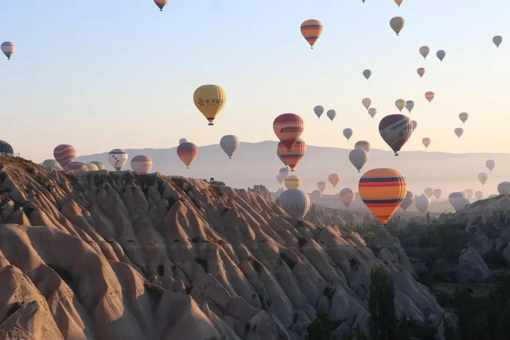 A hot air balloon floating over the majestic Abu Simbel temples at sunrise in Aswan, Egypt