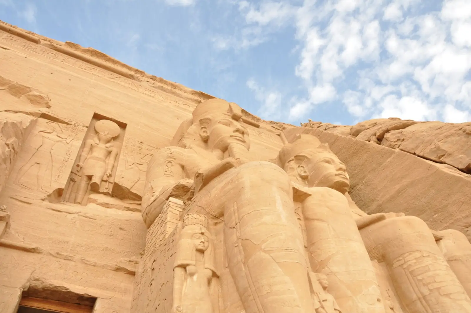 A clear winter day at the majestic Abu Simbel temples, with snow-capped mountains in the background
