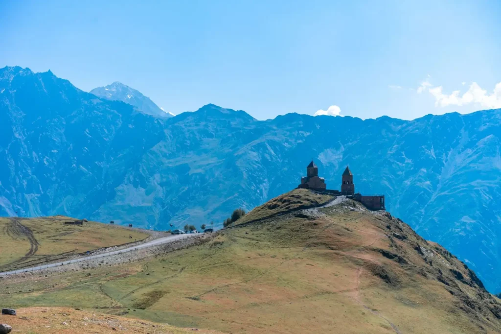 Gergeti Trinity Church perched on a ridge with Kazbek volcano behind it