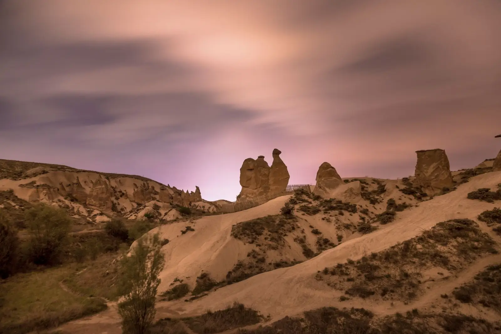 Fairy chimneys glowing under the soft glow of an autumn evening sky in Cappadocia