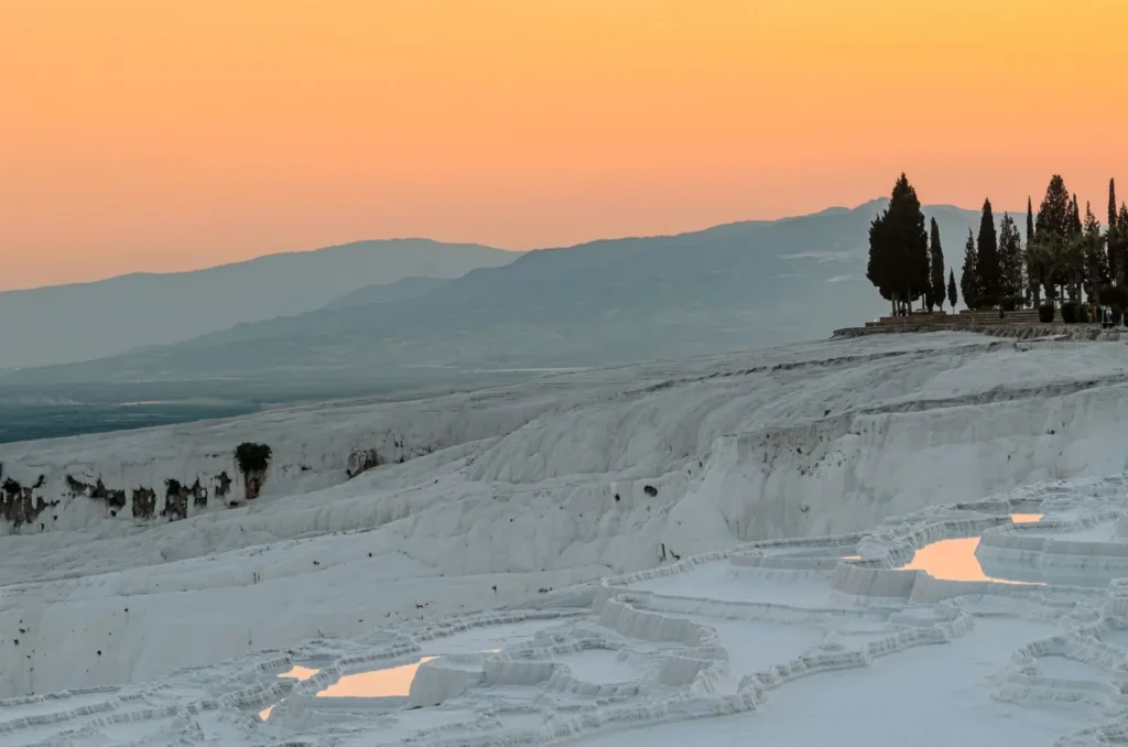 Sunset casts a warm glow on Pamukkale's thermal pools